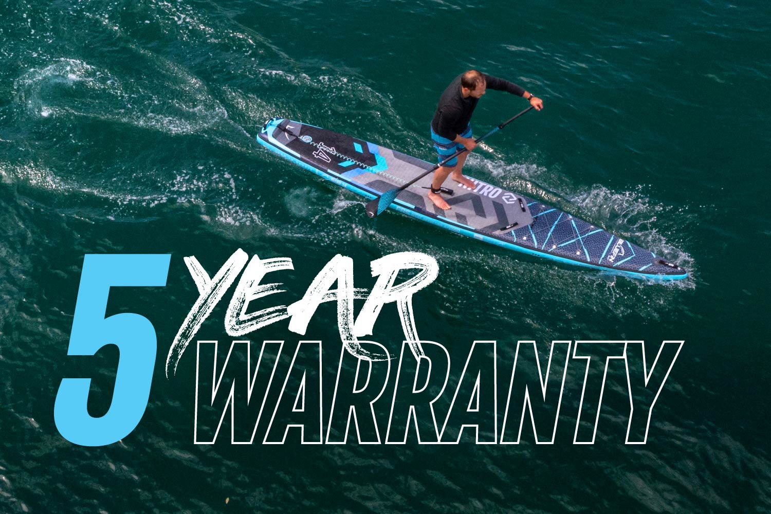 Paddleboarder on a blue inflatable paddleboard with a textured deck pad, paddling on water