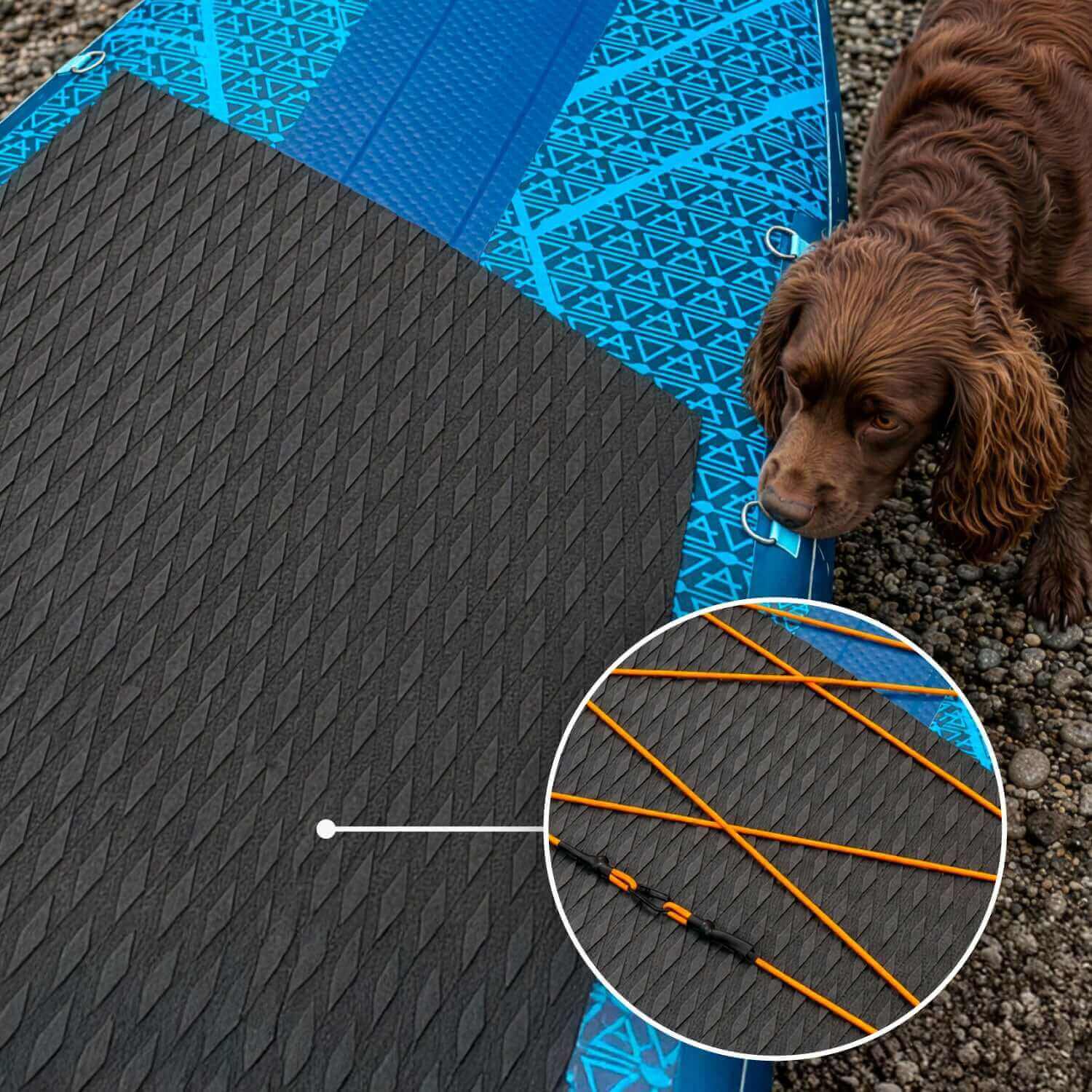 Opblaasbaar paddleboard met een zwarte, getextureerde antislipmat, oranje bungeekoorden en een bruine hond erbij