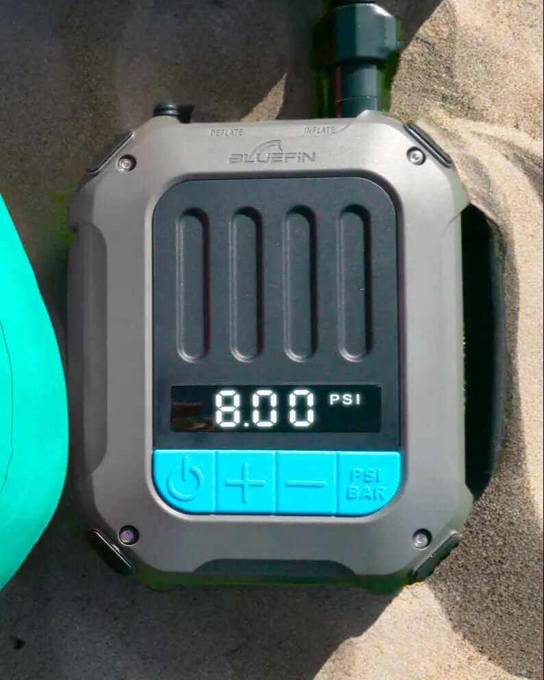 Digitale drukmeter die 8.00 PSI weergeeft, met opblaas- en leeglaatknoppen, op een zandige ondergrond.