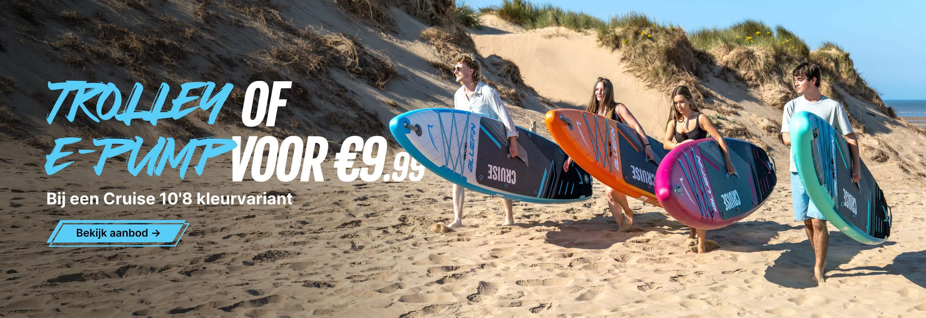 Group of four people carrying colorful paddleboards on a sandy beach with dune grass in the background.