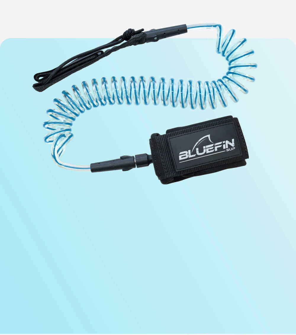 Coiled safety leash with black strap and blue cord, designed for paddleboarding use.