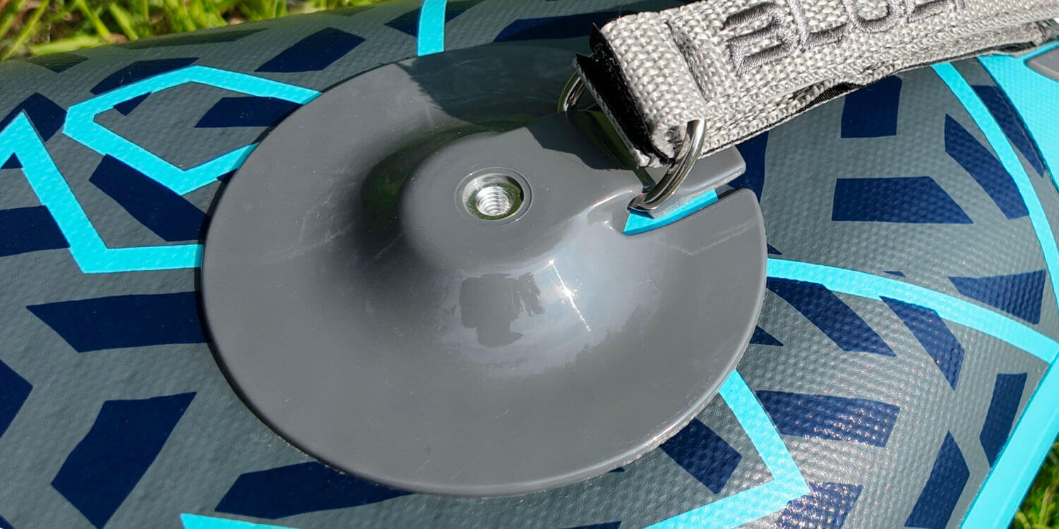 Inflatable paddleboard showing a gray fin attachment and a gray inflation valve on the surface
