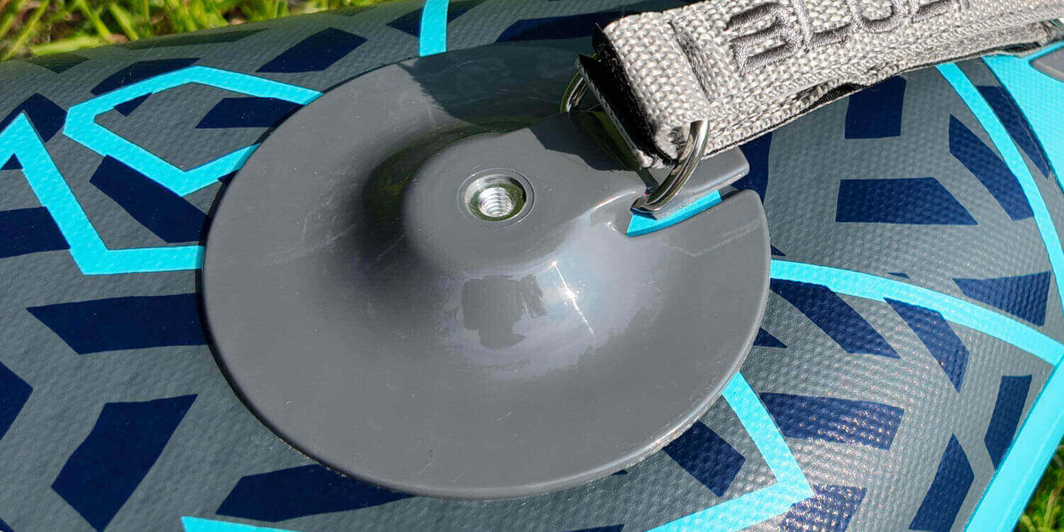 Inflatable paddleboard showing a gray fin attachment and a gray inflation valve on the surface
