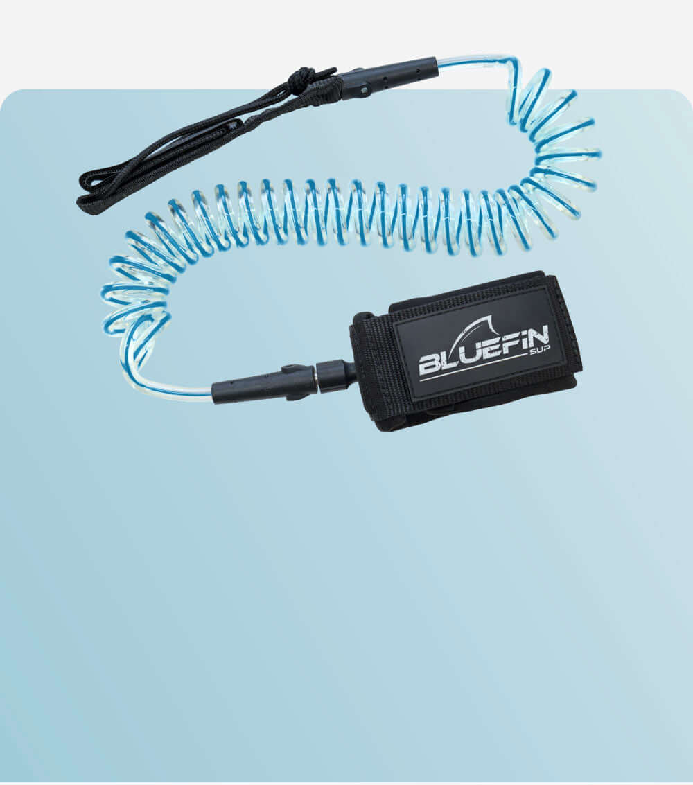 Coiled blue safety leash with black strap and BLUEFIN SUP logo on a light background