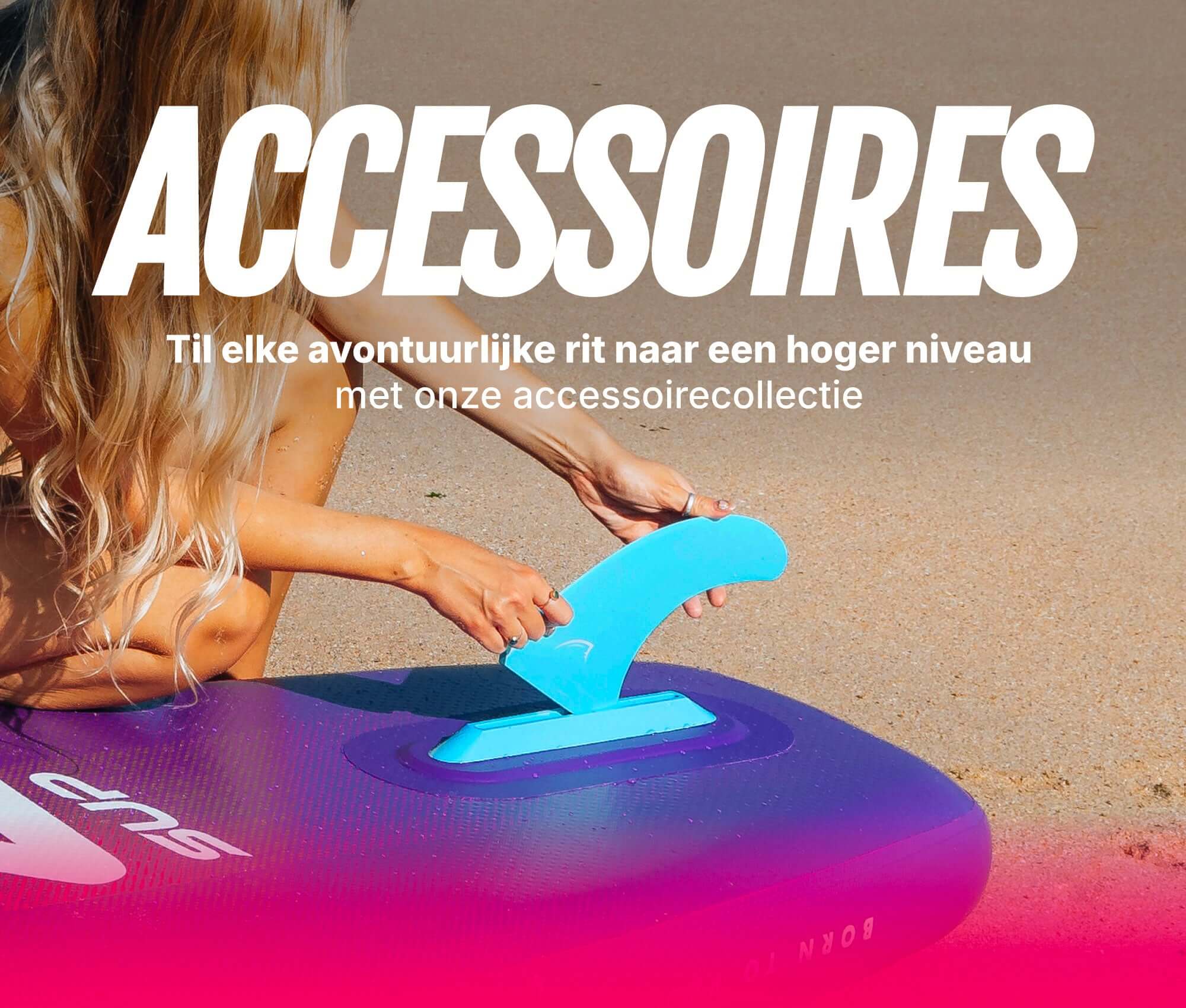 Person attaching a blue fin to a purple inflatable paddleboard on a sandy beach