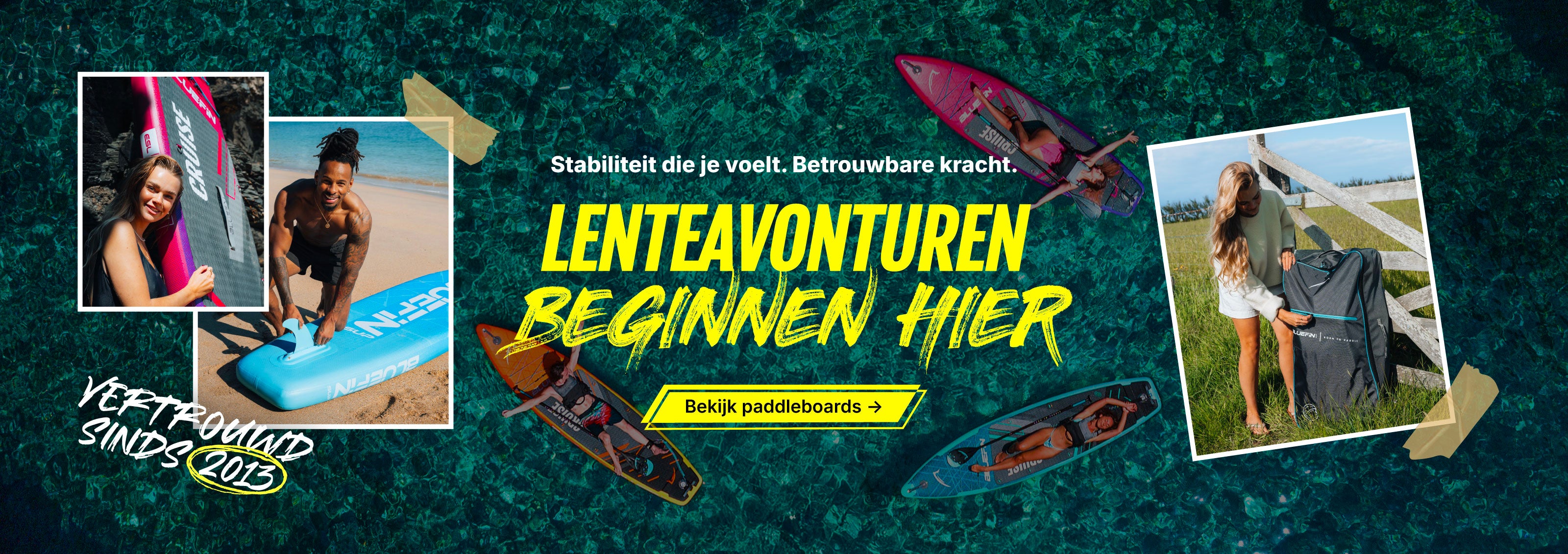 Two people with paddleboards on a beach, one holding a backpack, vibrant water in background.